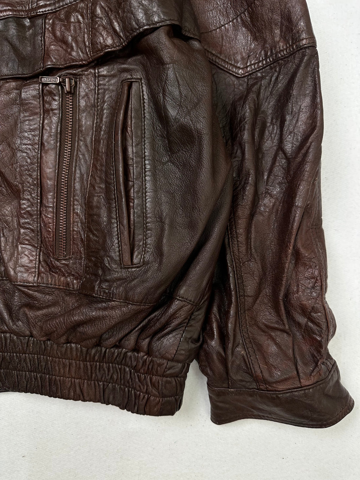 Side pocket and hem of the size XL burgundy leather flight jacket, up close