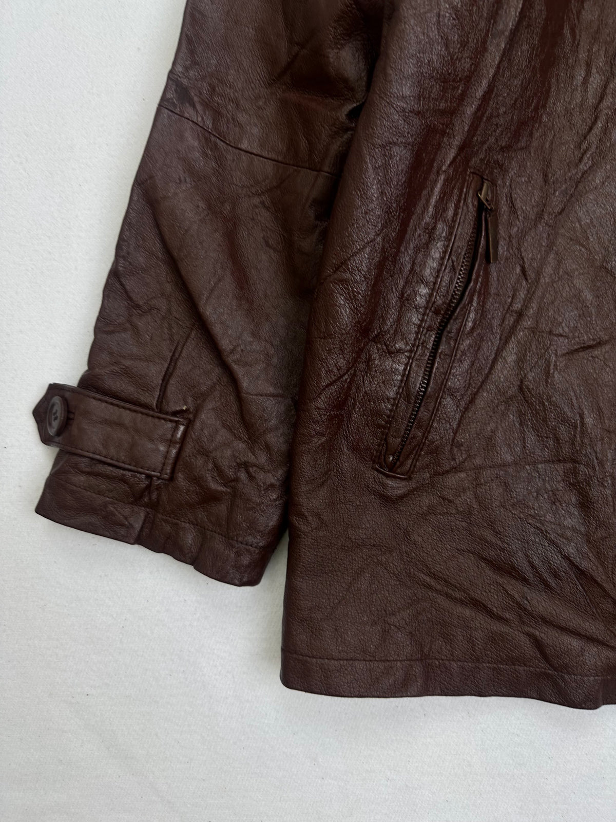 Close detail of the pockets and cuff on the size L burgundy leather vintage jacket