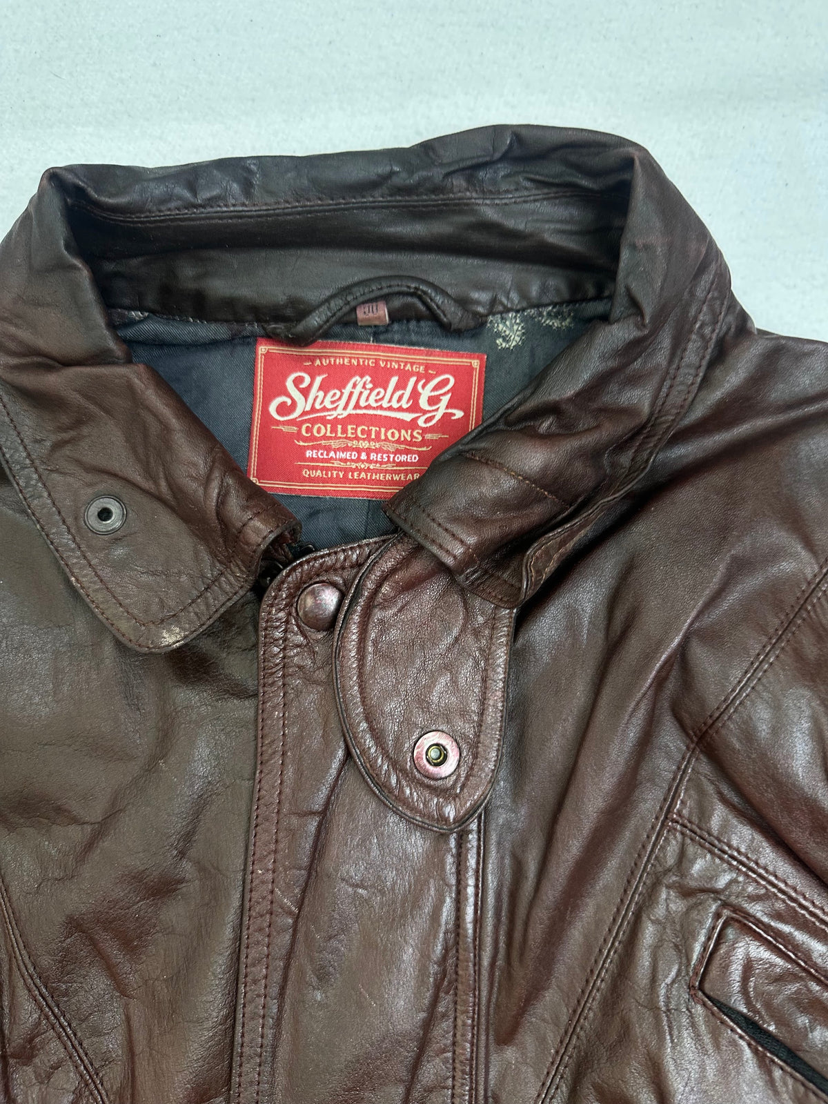 Collar and zip of the size M burgundy leather flight jacket, up close