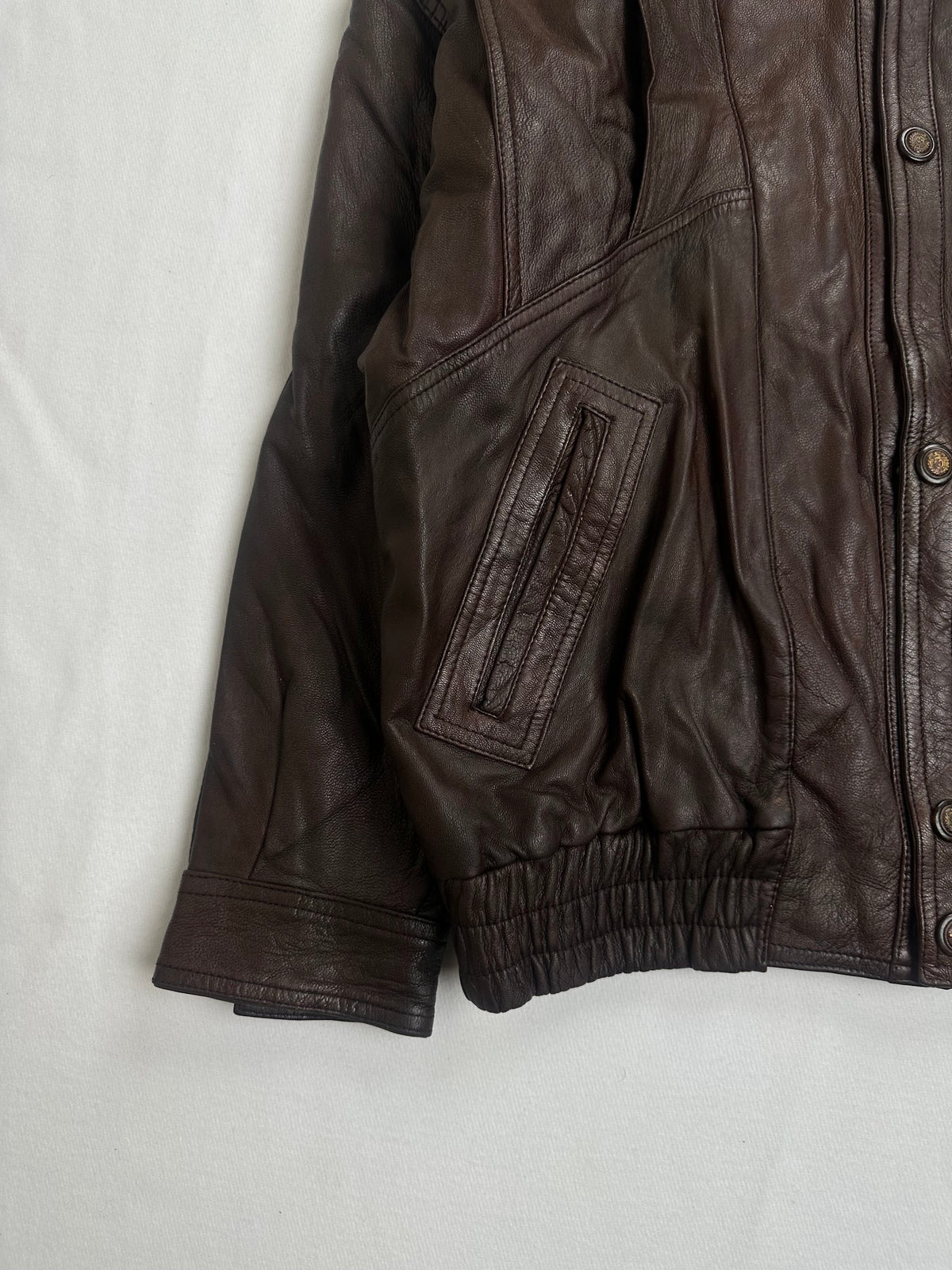 Twin welt chest pockets above the shirred leather waist on the brown harrington