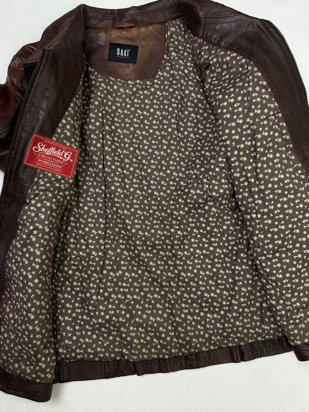The size S burgundy leather vintage jacket opened to show the lining