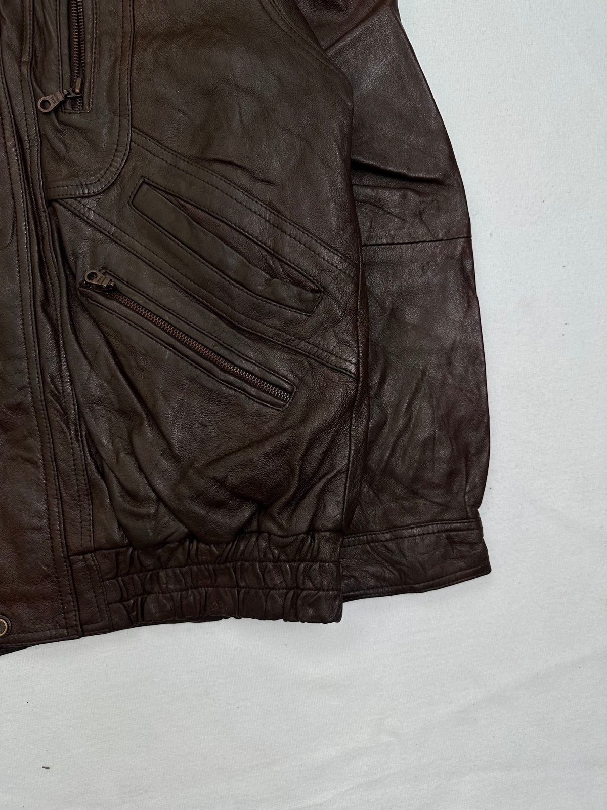 Side pocket and hem of the size M burgundy leather vintage jacket, up close