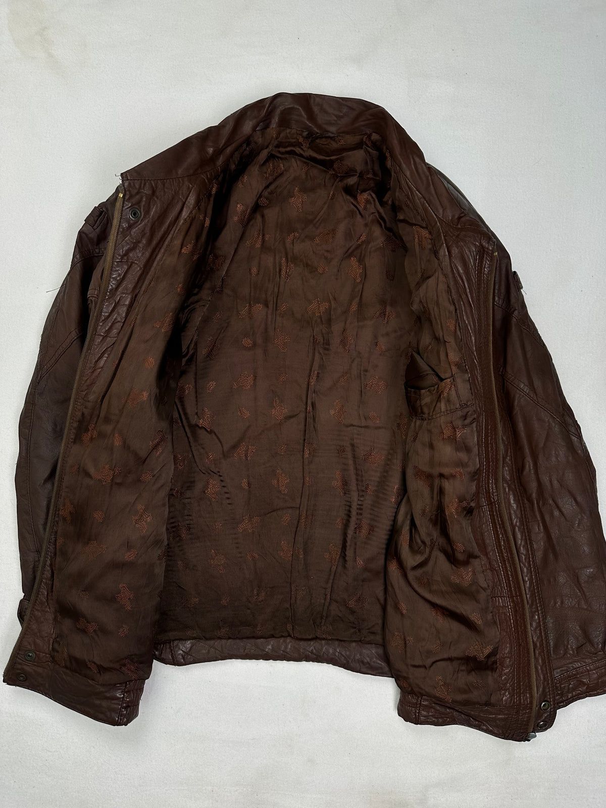 The size XL burgundy leather vintage jacket opened to show the lining