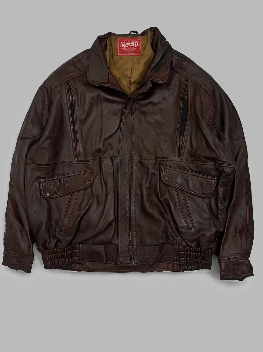 Burgundy leather flight jacket laid flat, wide pointed collar worn standing, twin snap flap pockets and zip chest pockets