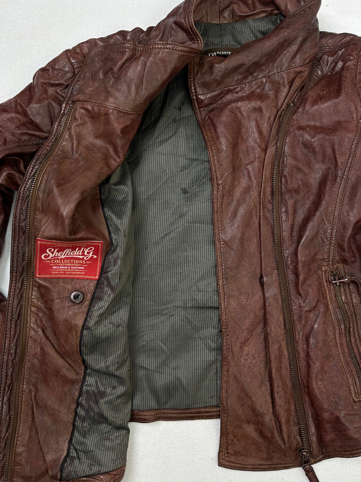 The size S burgundy leather biker jacket opened to show the lining