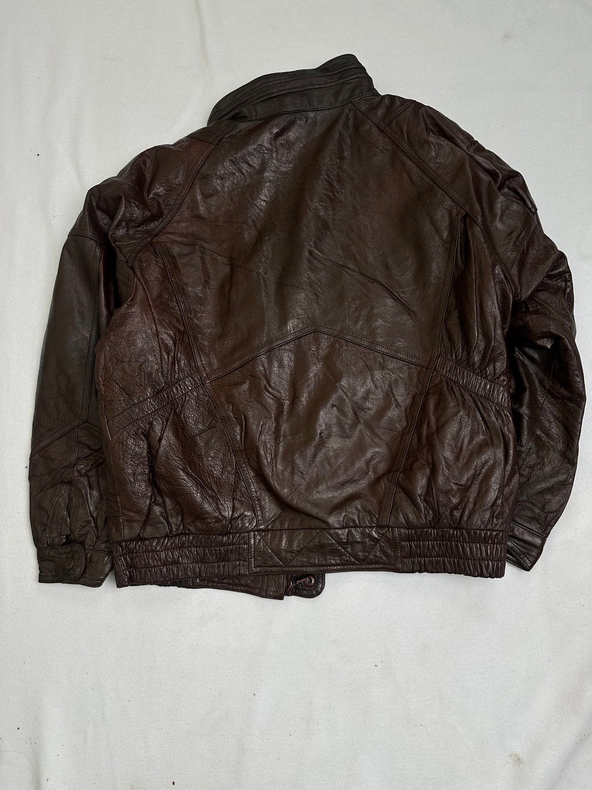 Back of the brown leather jacket showing creasing through the body and sleeves