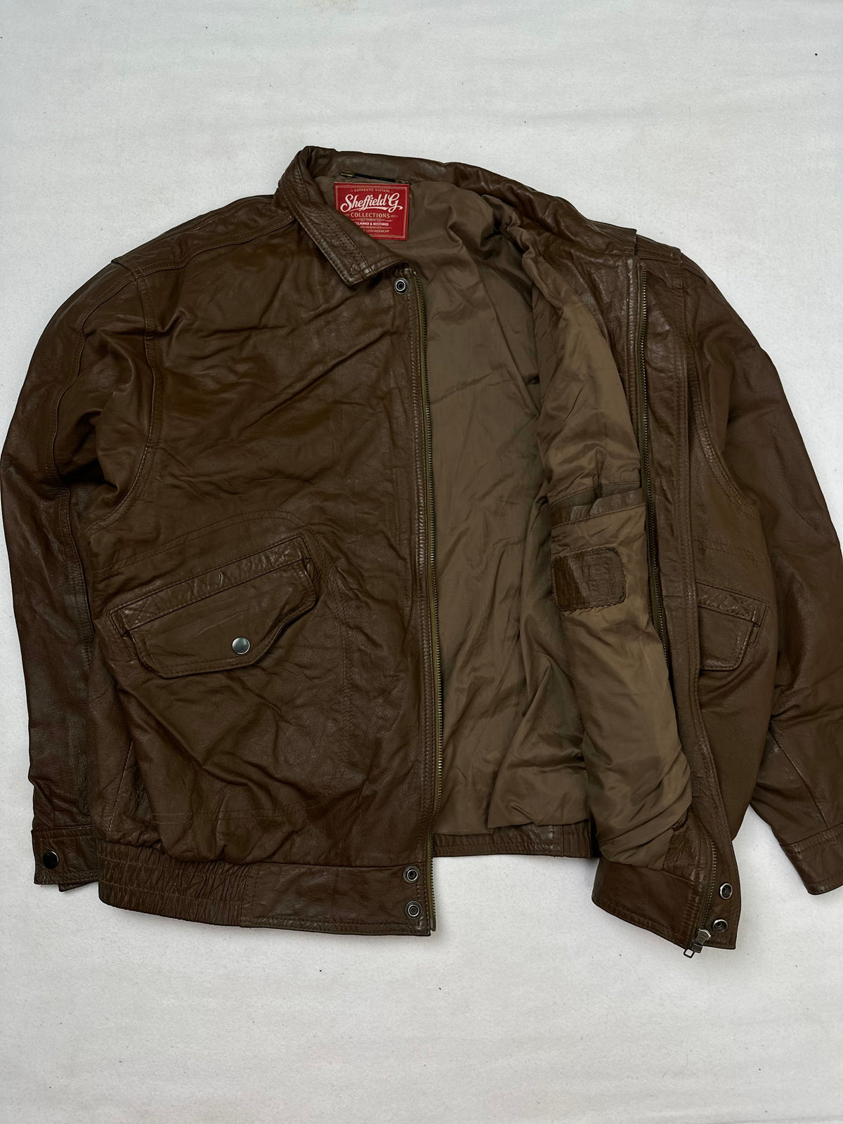 The size M brown leather flight jacket opened to show the lining