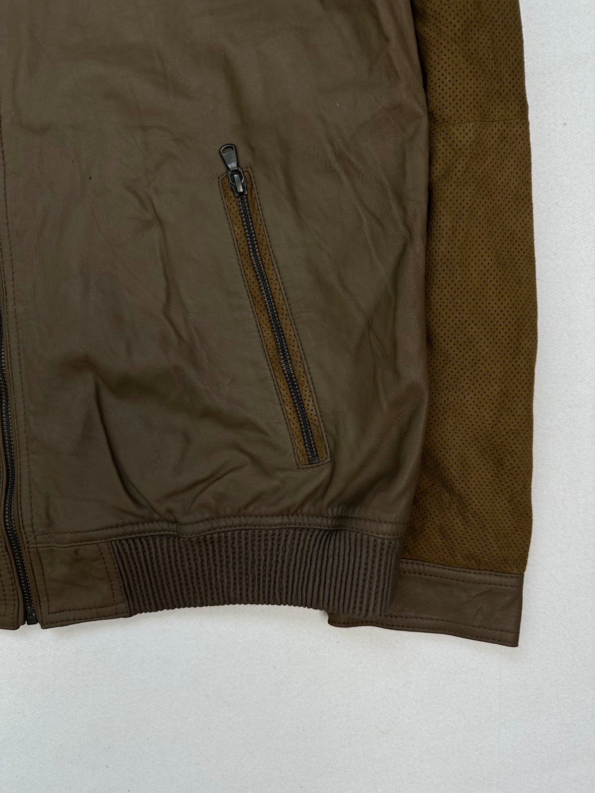 Side pocket and hem of the size L brown leather cafe racer jacket, up close