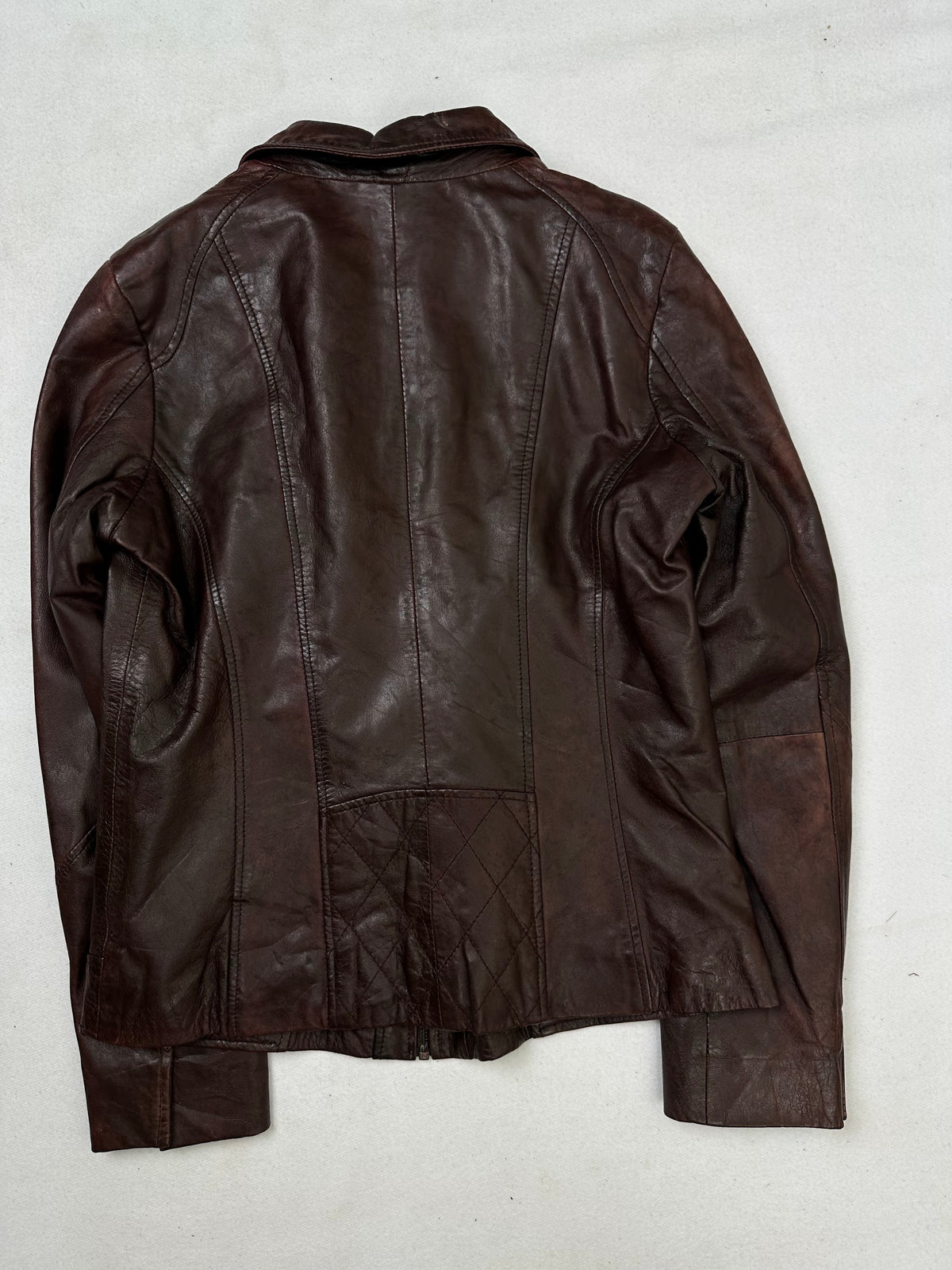Back of the size S burgundy leather vintage jacket, laid flat