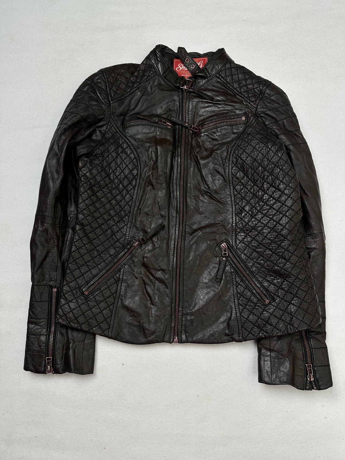Front of the size S brown leather cafe racer jacket, laid flat and unedited