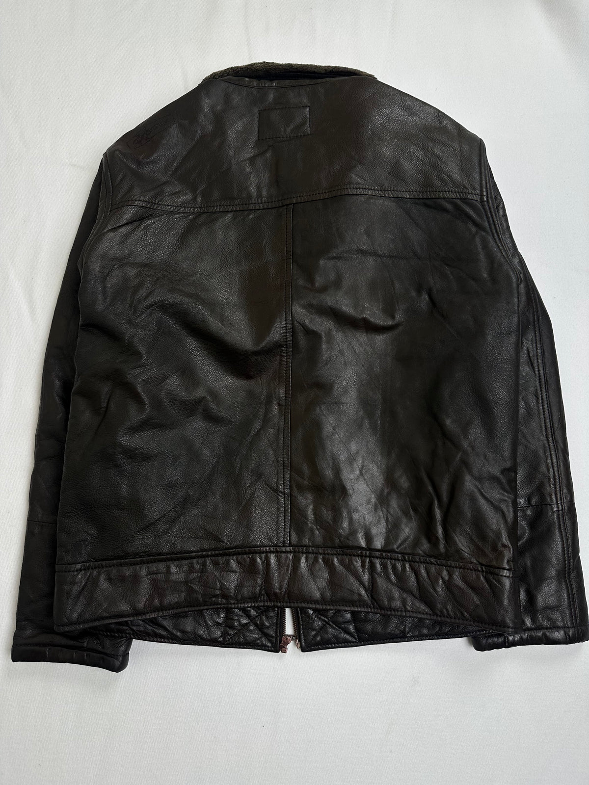 Reverse of the size L brown flight jacket laid flat