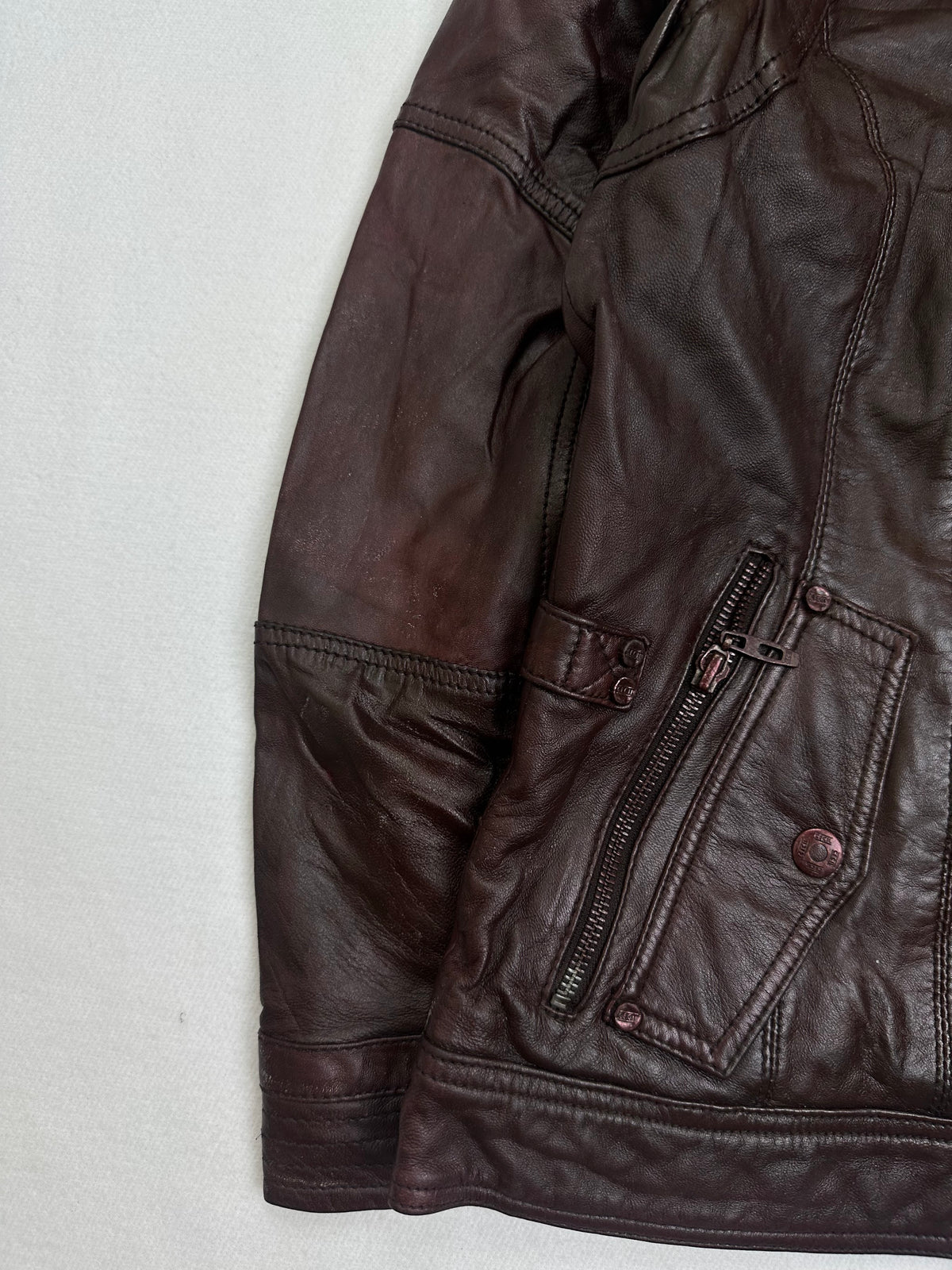 Close detail of the pockets and cuff on the size M burgundy leather cafe racer jacket