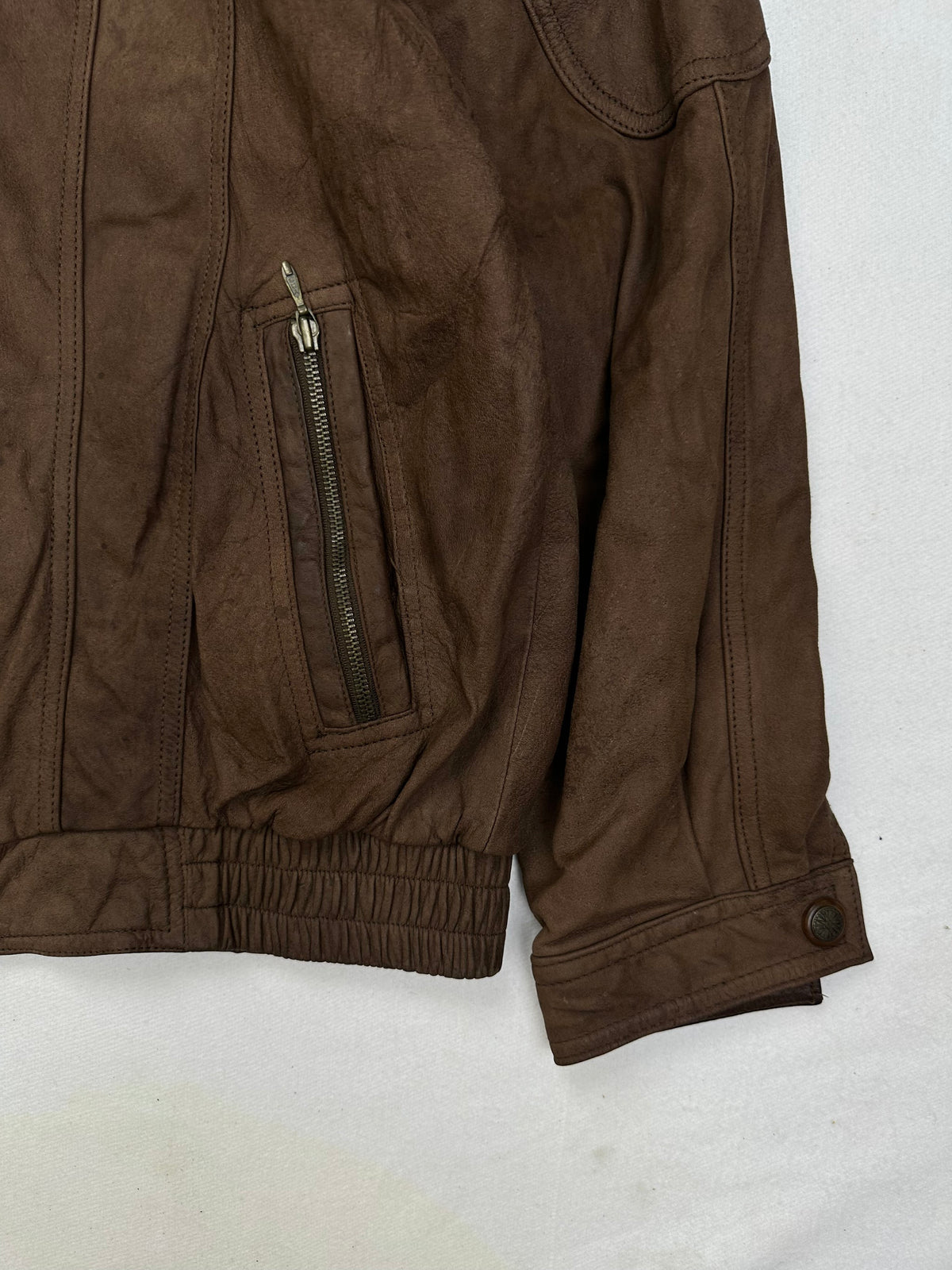 Side pocket and hem of the size L brown leather flight jacket, up close