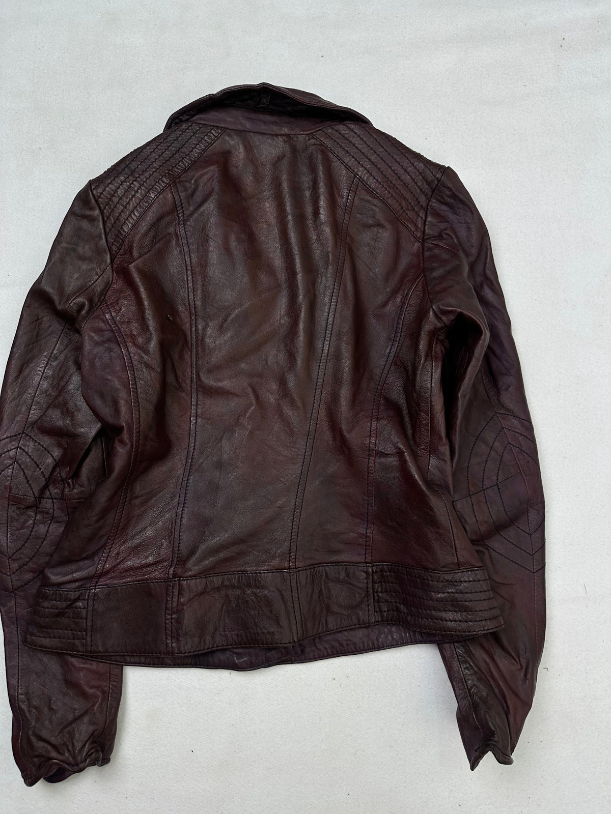 Back of the size S burgundy leather biker jacket, laid flat
