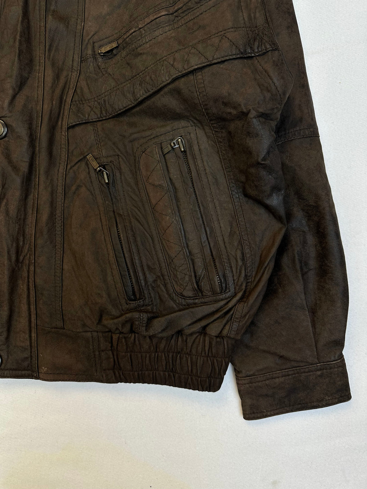 Side pocket and hem of the size L brown leather flight jacket, up close