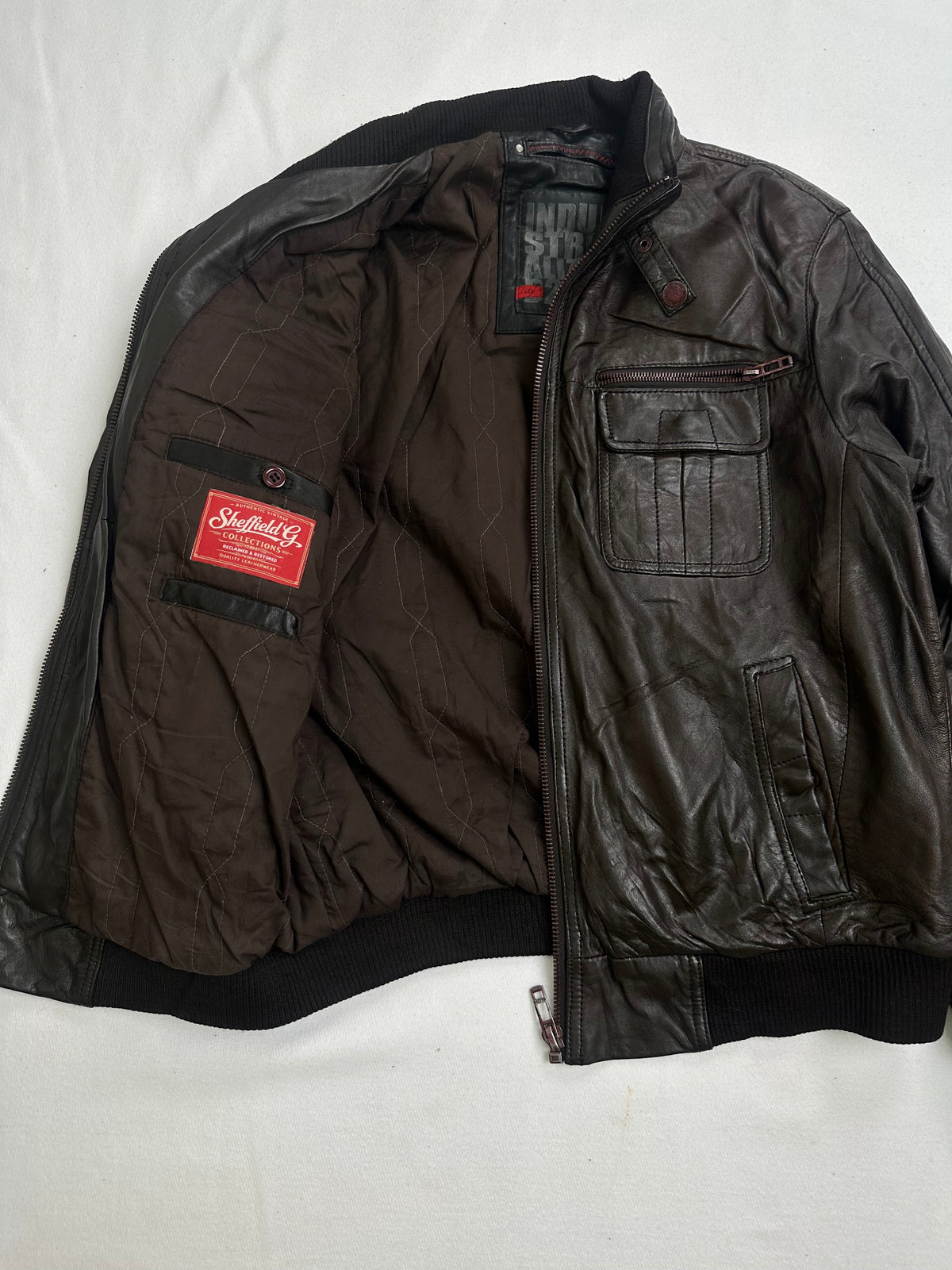 Zipped flap chest pocket above a slanted hand pocket