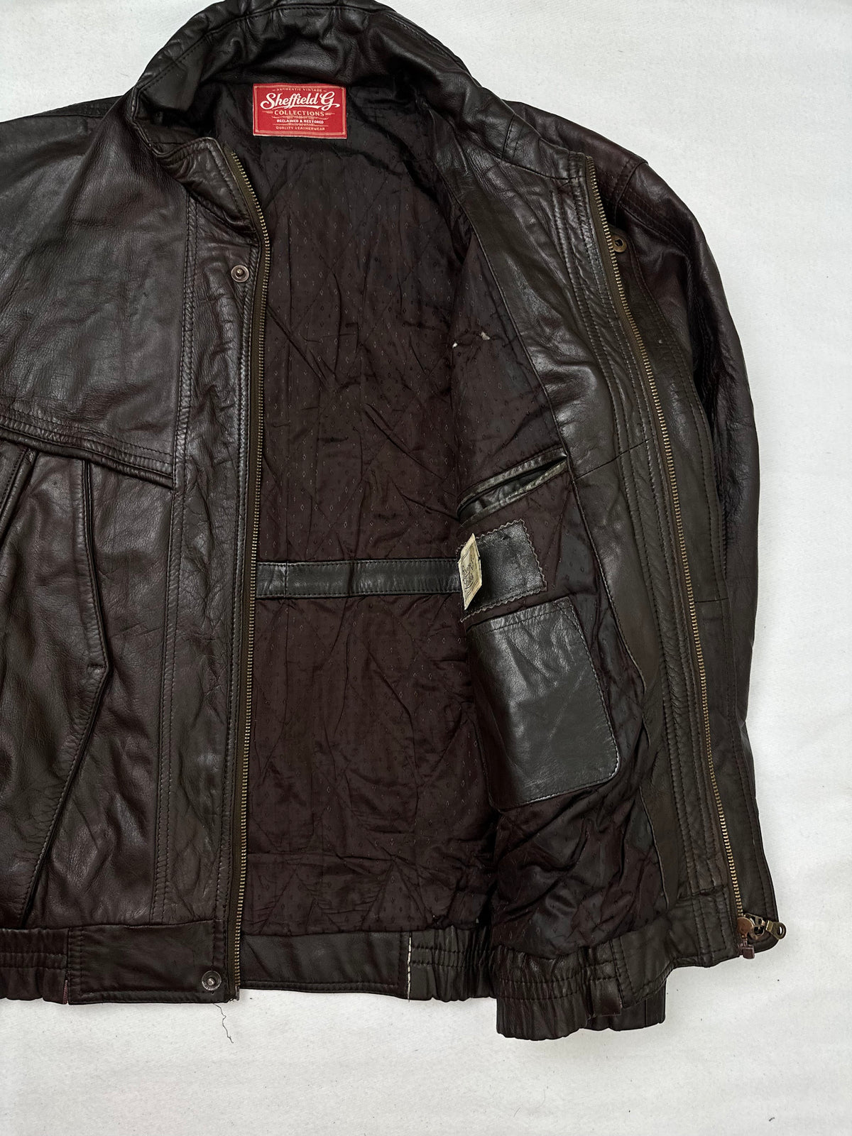 The size XL brown leather flight jacket opened to show the lining
