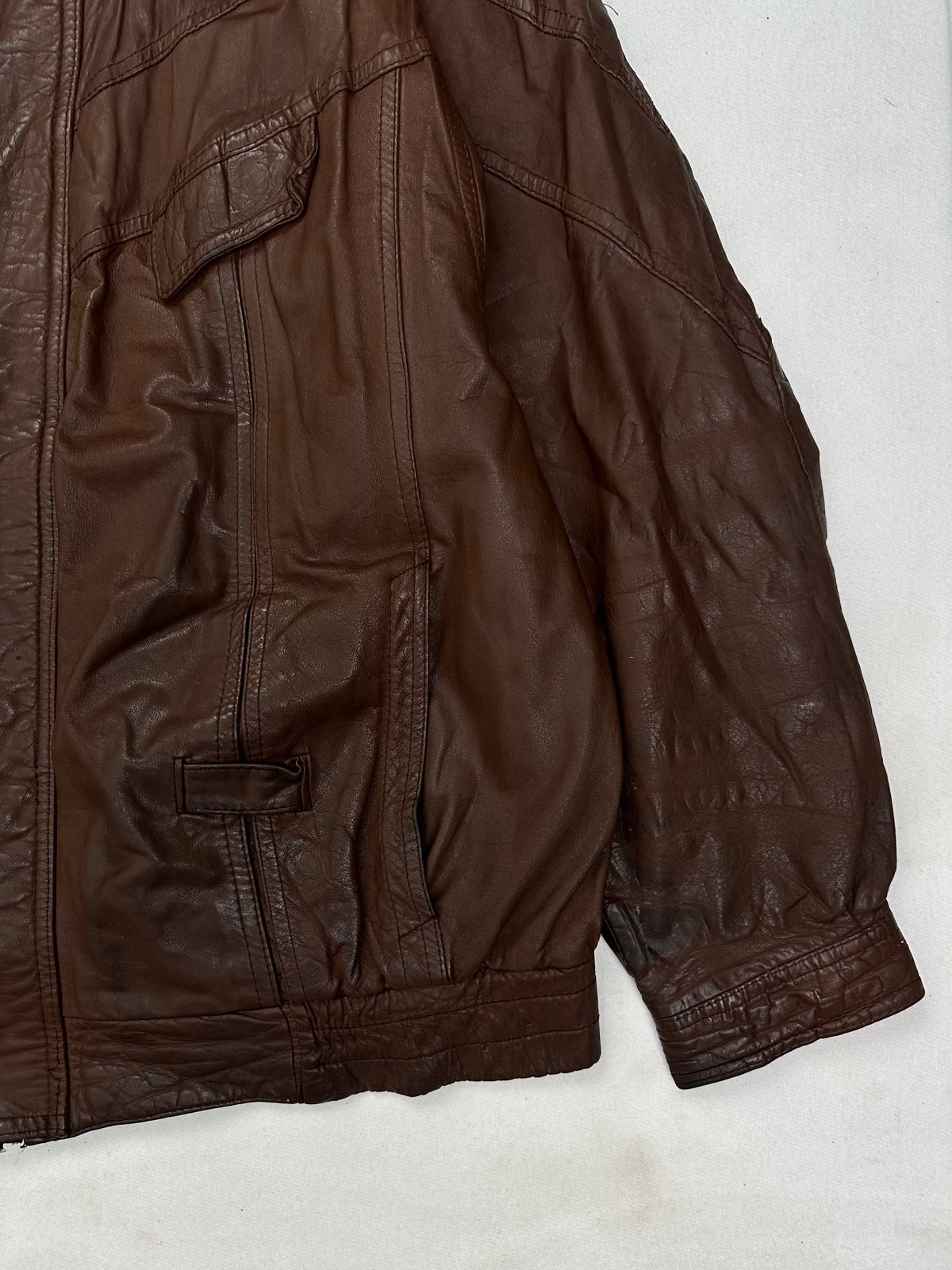 Side pocket and hem of the size XL burgundy leather vintage jacket, up close