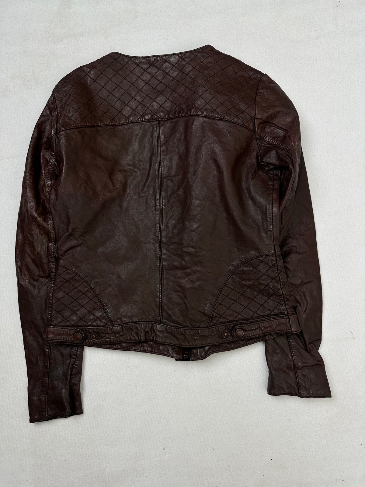 Back of the size S burgundy leather vintage jacket, laid flat