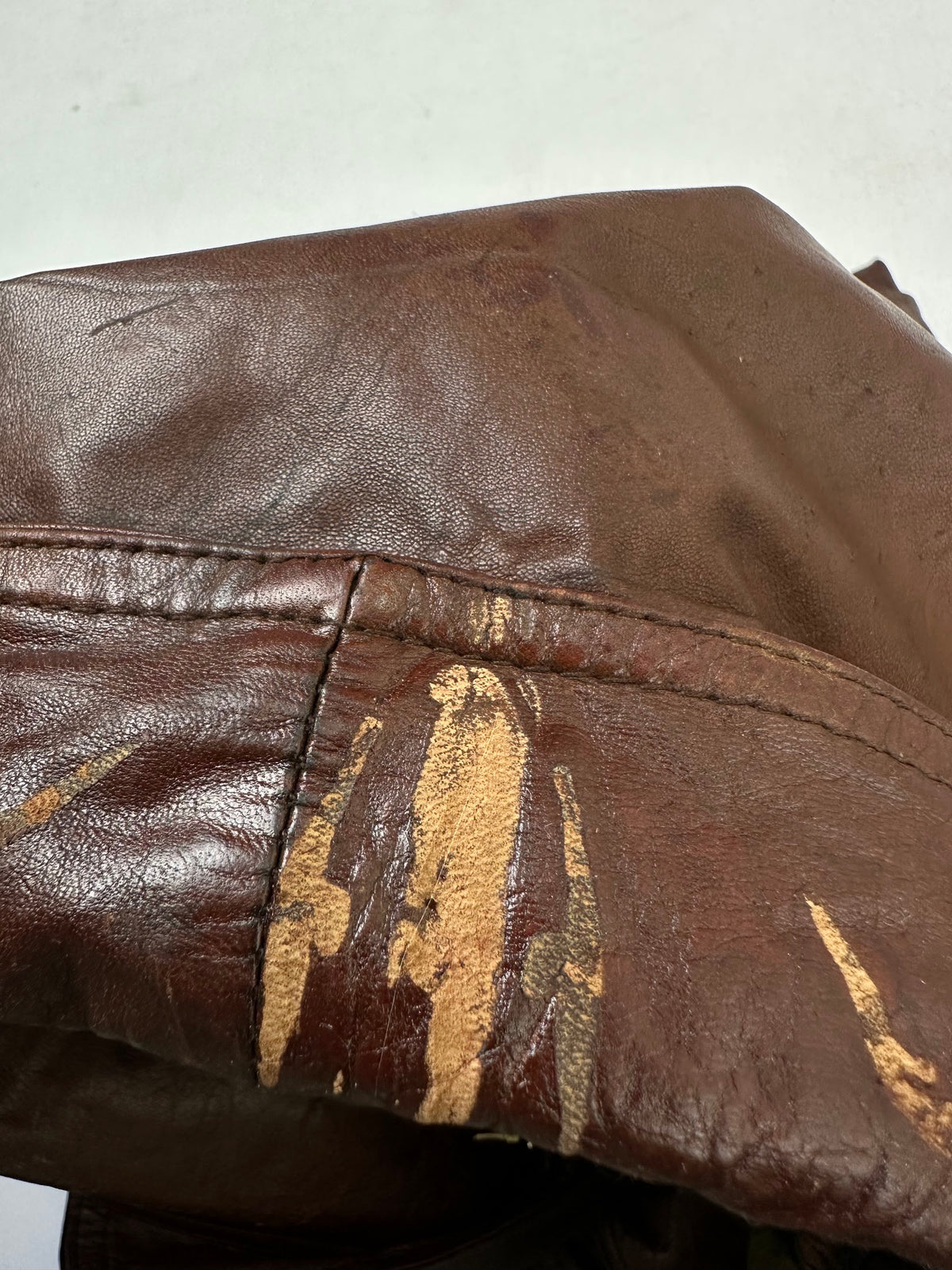 A small mark on the size L burgundy leather flight jacket, shown up close