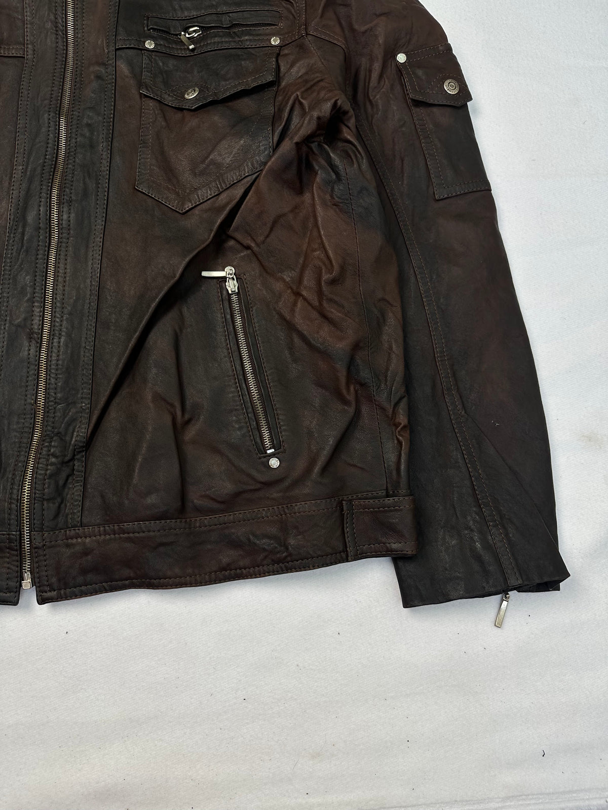 Side pocket and hem of the size L brown leather cafe racer jacket, up close