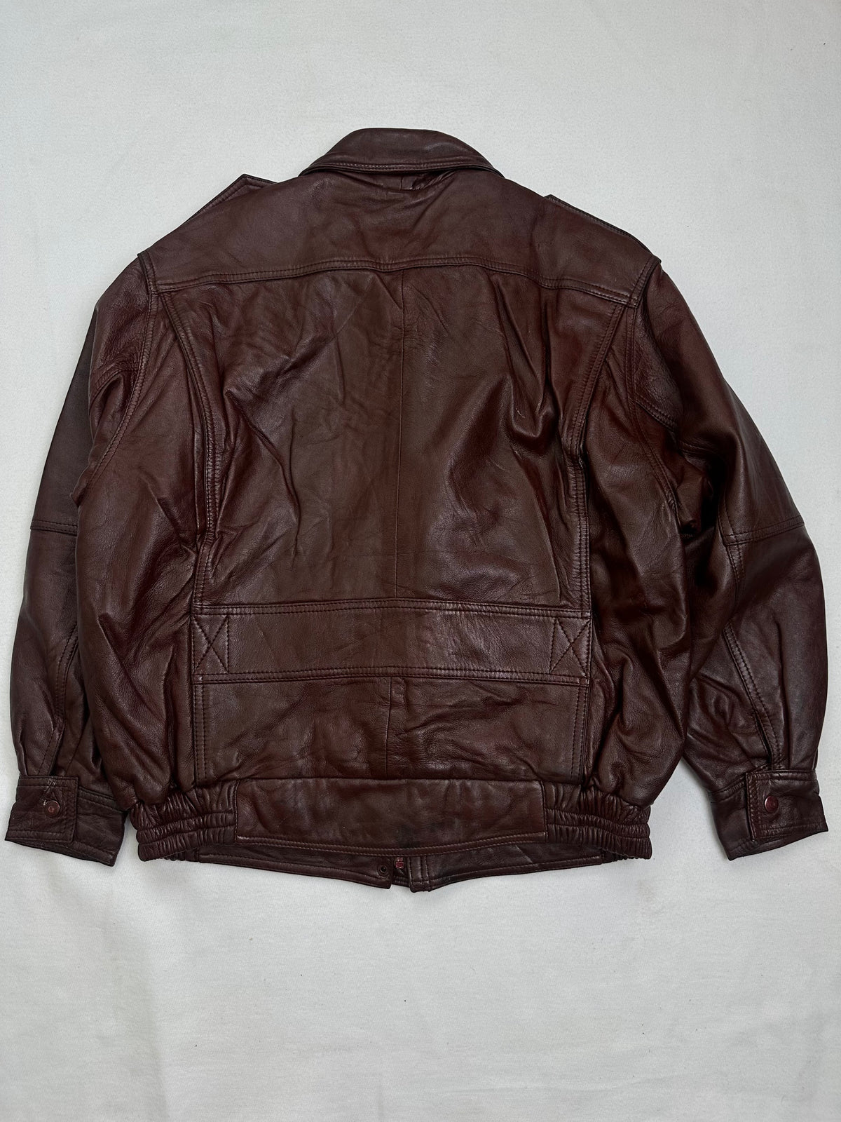 Back of the size L burgundy leather flight jacket, laid flat
