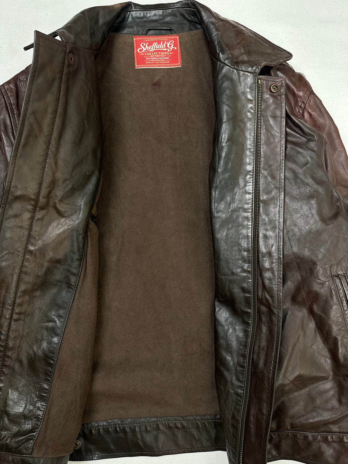 The size S burgundy leather vintage jacket opened to show the lining