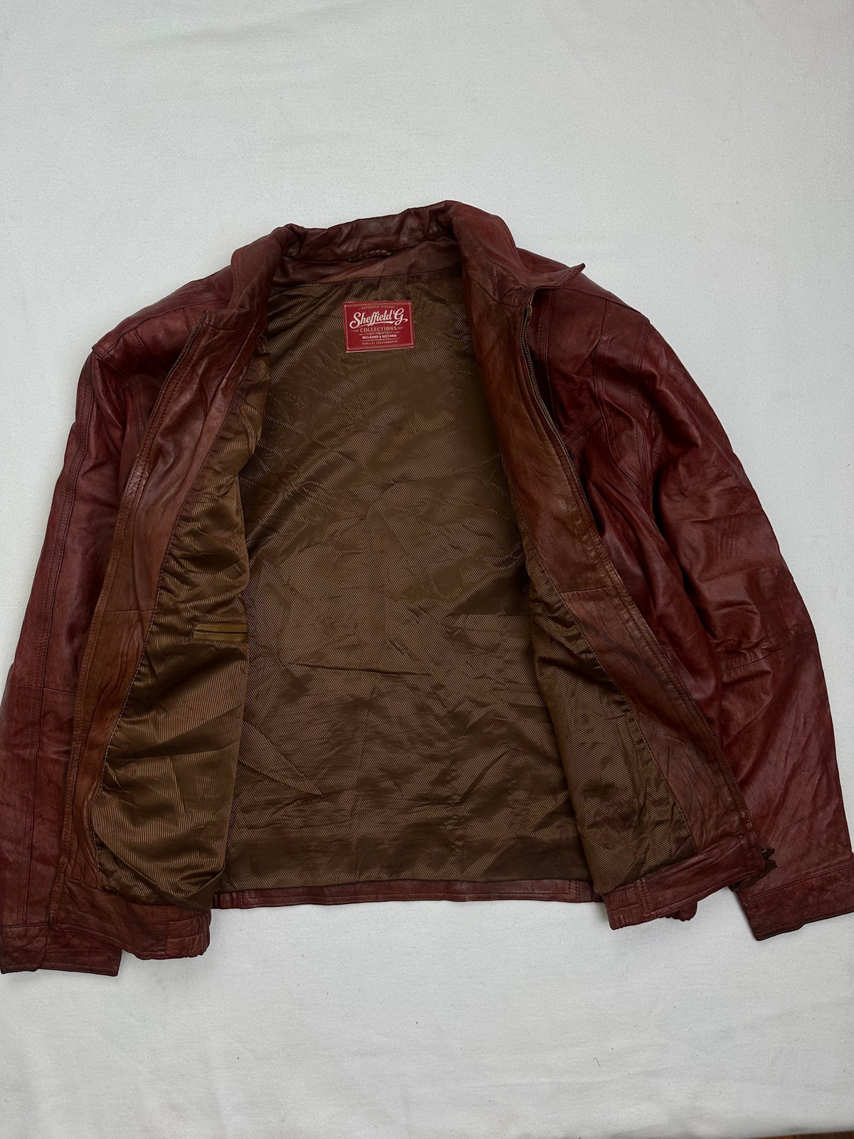 The size XL burgundy leather harrington jacket opened to show the lining
