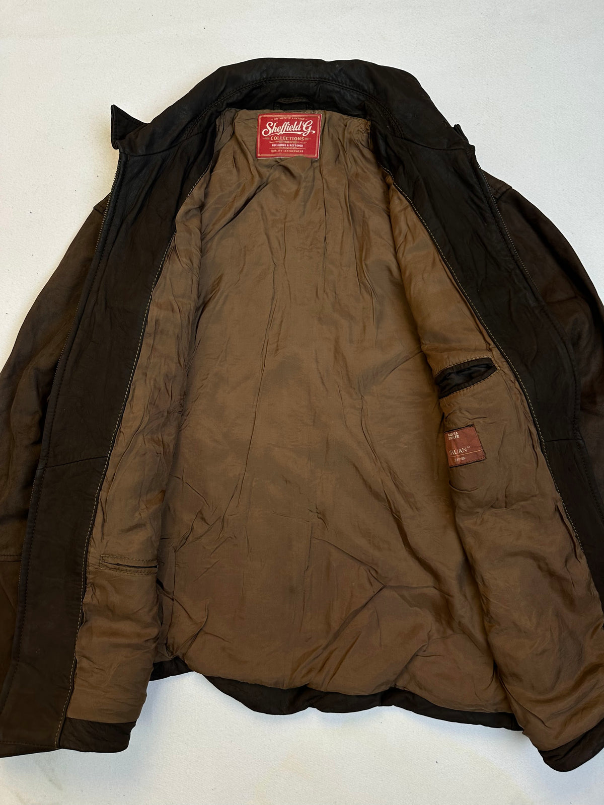The size XL brown leather vintage jacket opened to show the lining