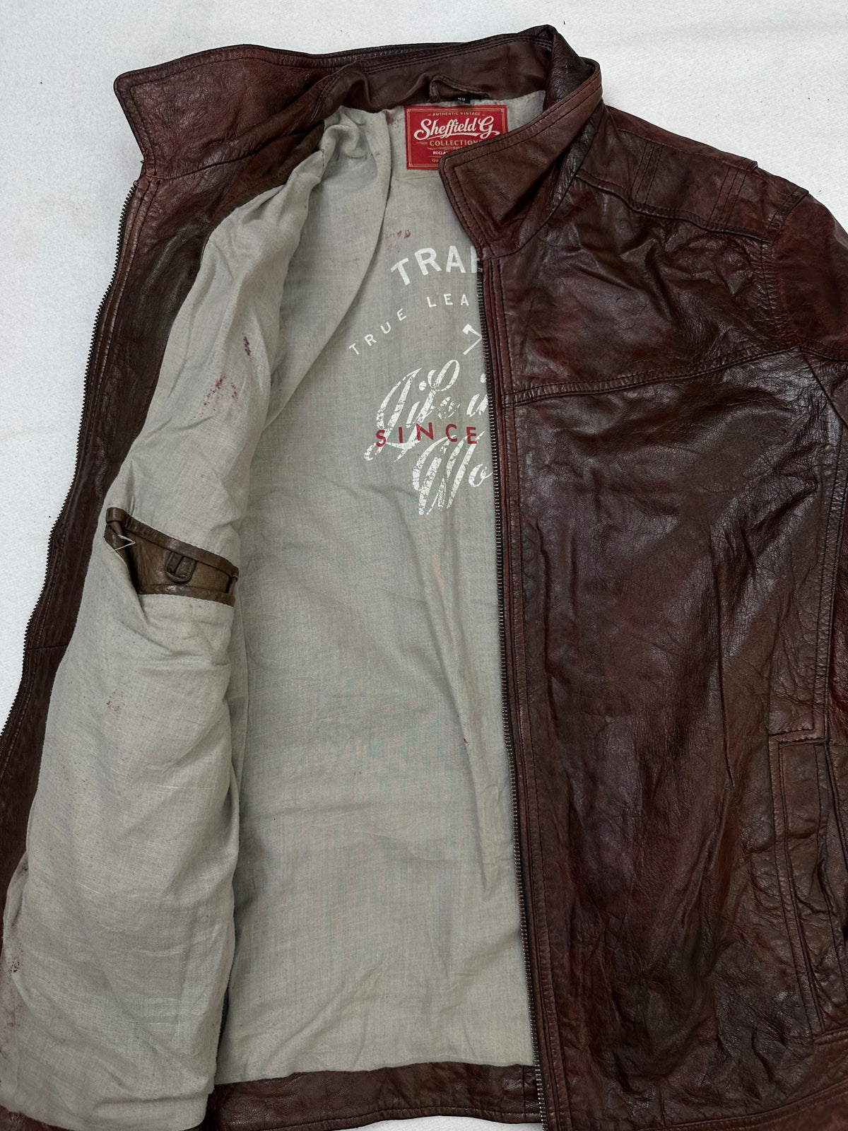 The size L burgundy leather vintage jacket opened to show the lining