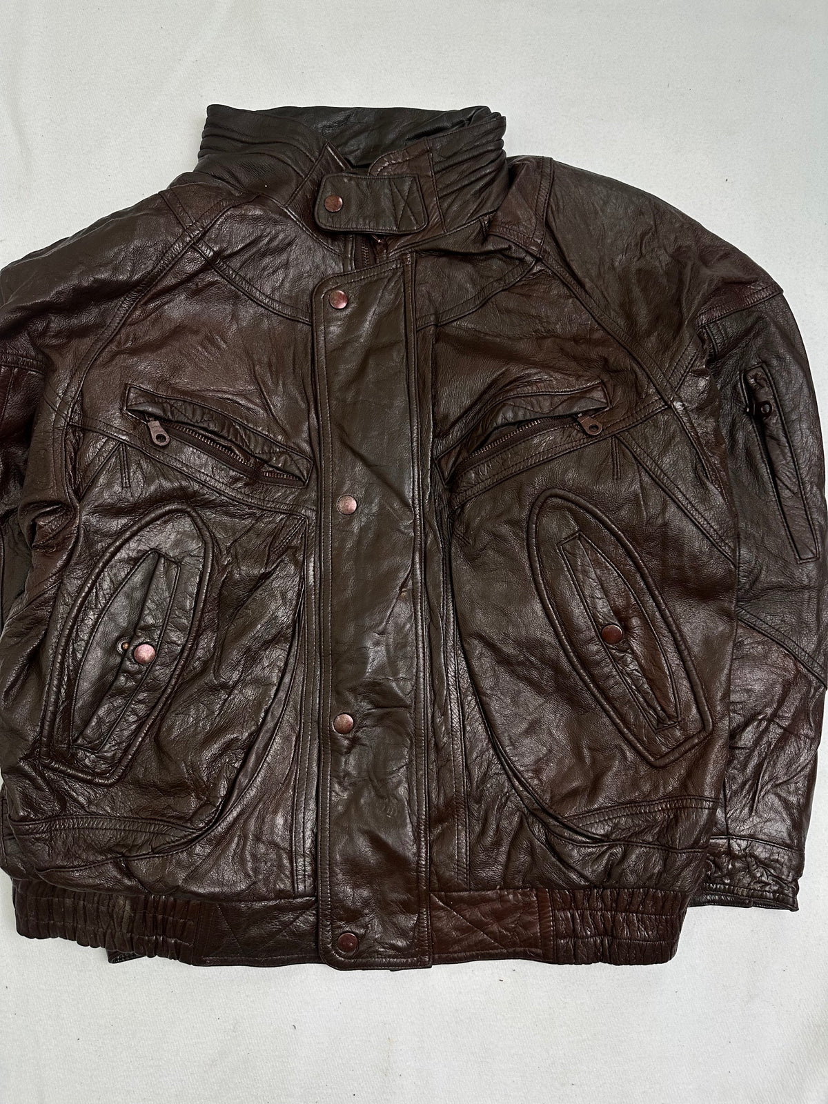 Front of the jacket showing the copper press studs down the storm placket and the oval welt hand pockets