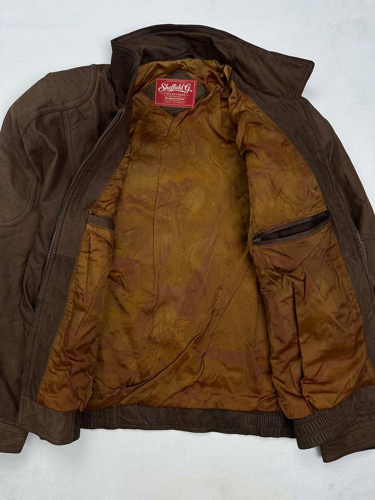 The size L brown leather flight jacket opened to show the lining