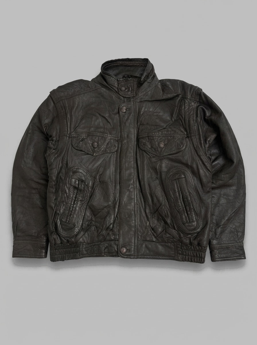 Dark brown leather flight jacket laid flat, funnel collar with snap throat tab, storm flap over the zip and oval padded pocket panels