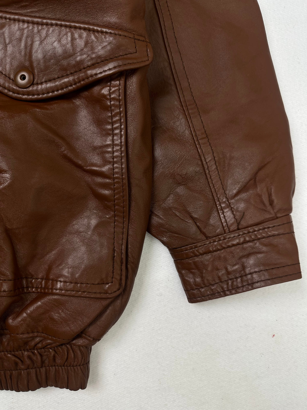 Side pocket and hem of the size L brown leather flight jacket, up close