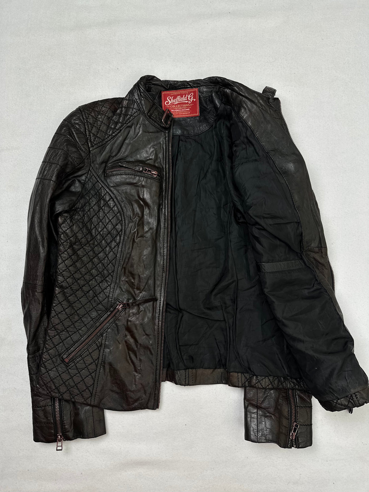 The size S brown leather cafe racer jacket opened to show the lining