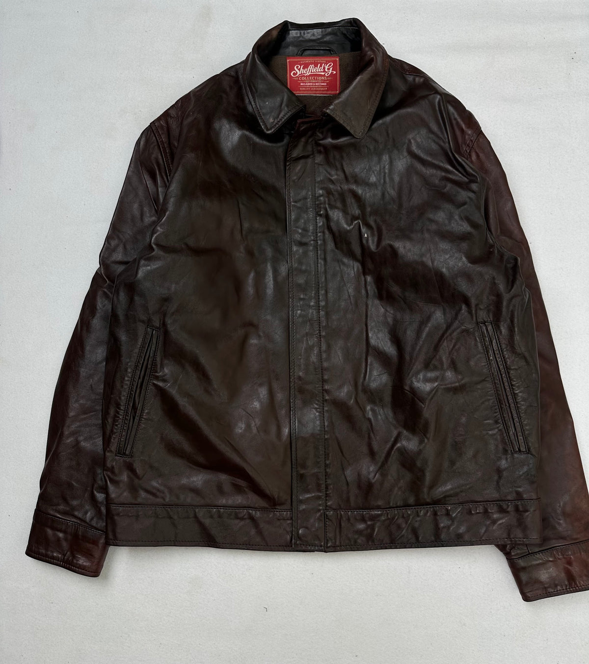 Front of the size S burgundy leather vintage jacket, laid flat and unedited