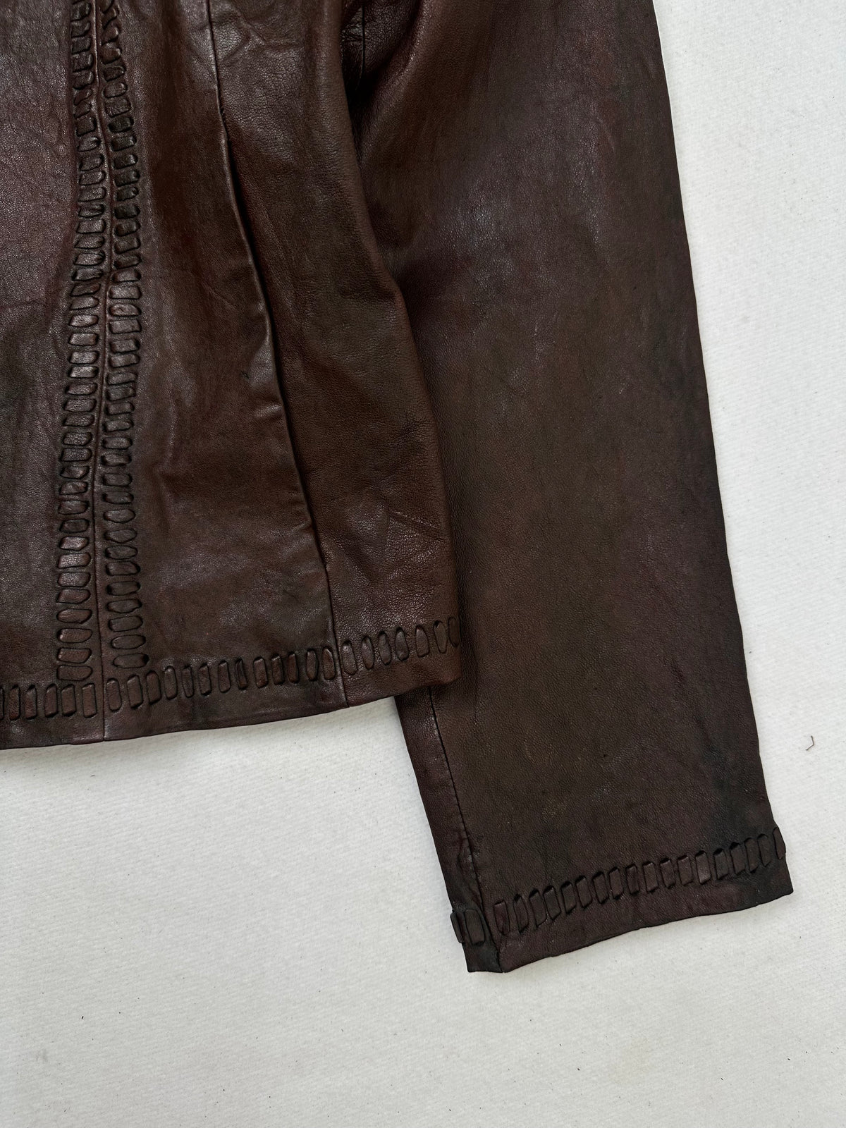 Side pocket and hem of the size S burgundy leather vintage jacket, up close