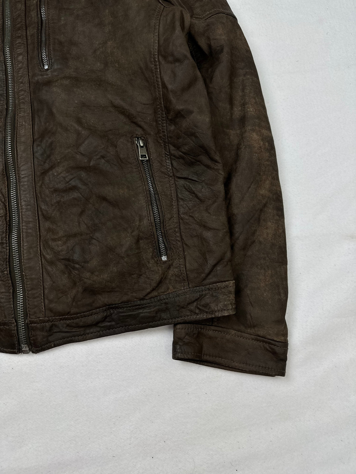 Side pocket and hem of the size M brown leather cafe racer jacket, up close