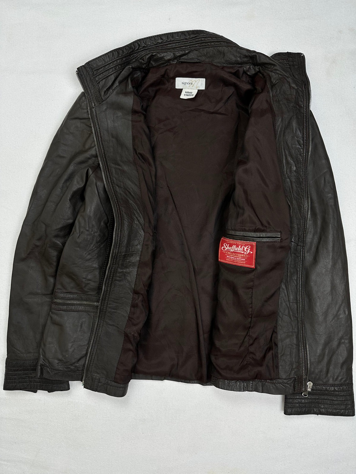 The size S brown leather cafe racer jacket opened to show the lining