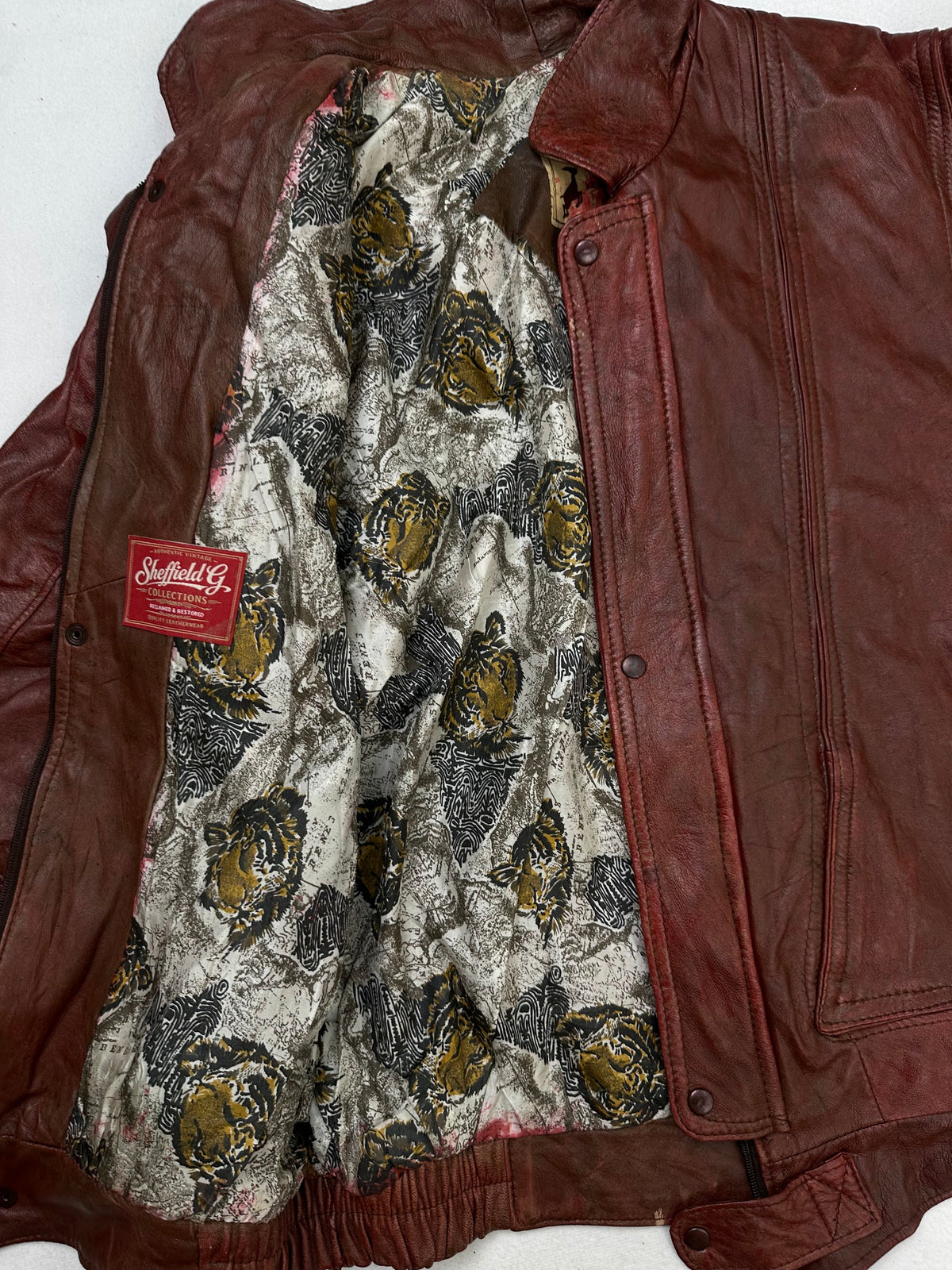 The size L burgundy leather flight jacket opened to show the lining