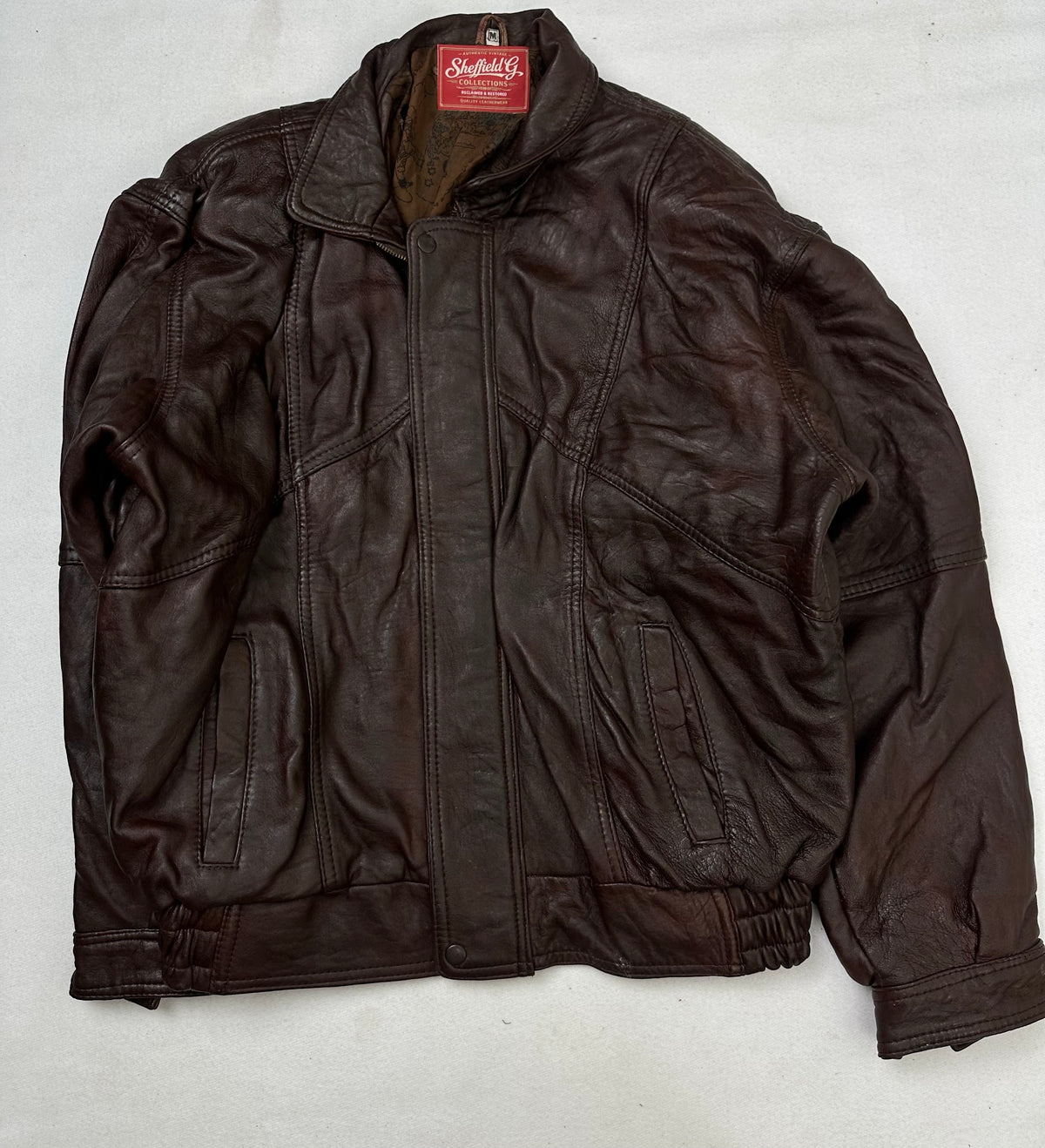 Front of the size L burgundy leather flight jacket, laid flat and unedited