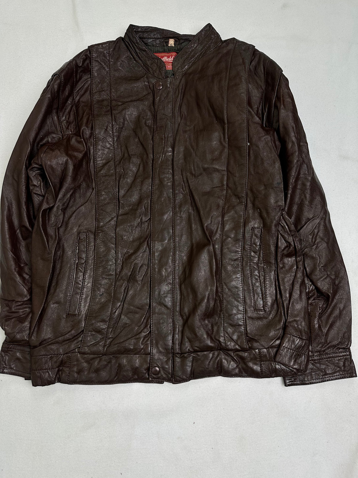 Low band collar above the snapped leather storm placket