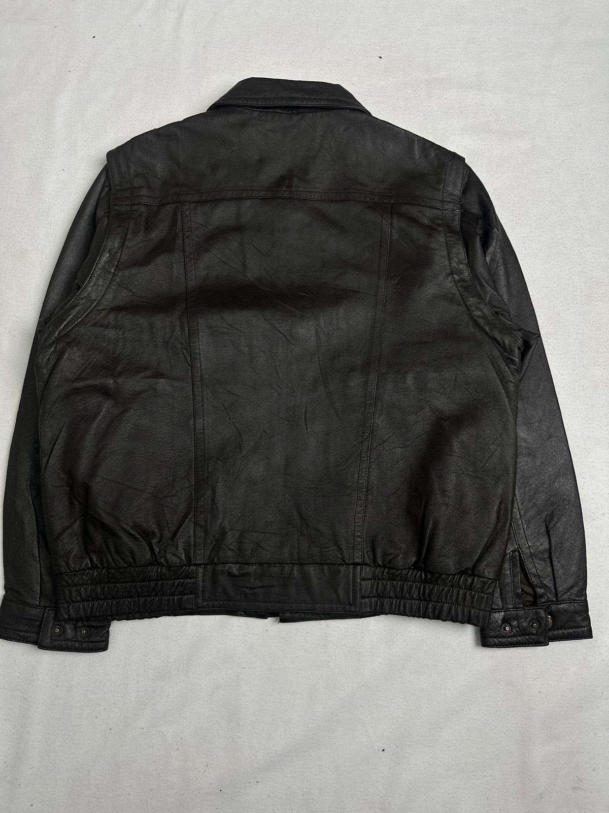 Clasps running down the front over the zip below a pointed collar