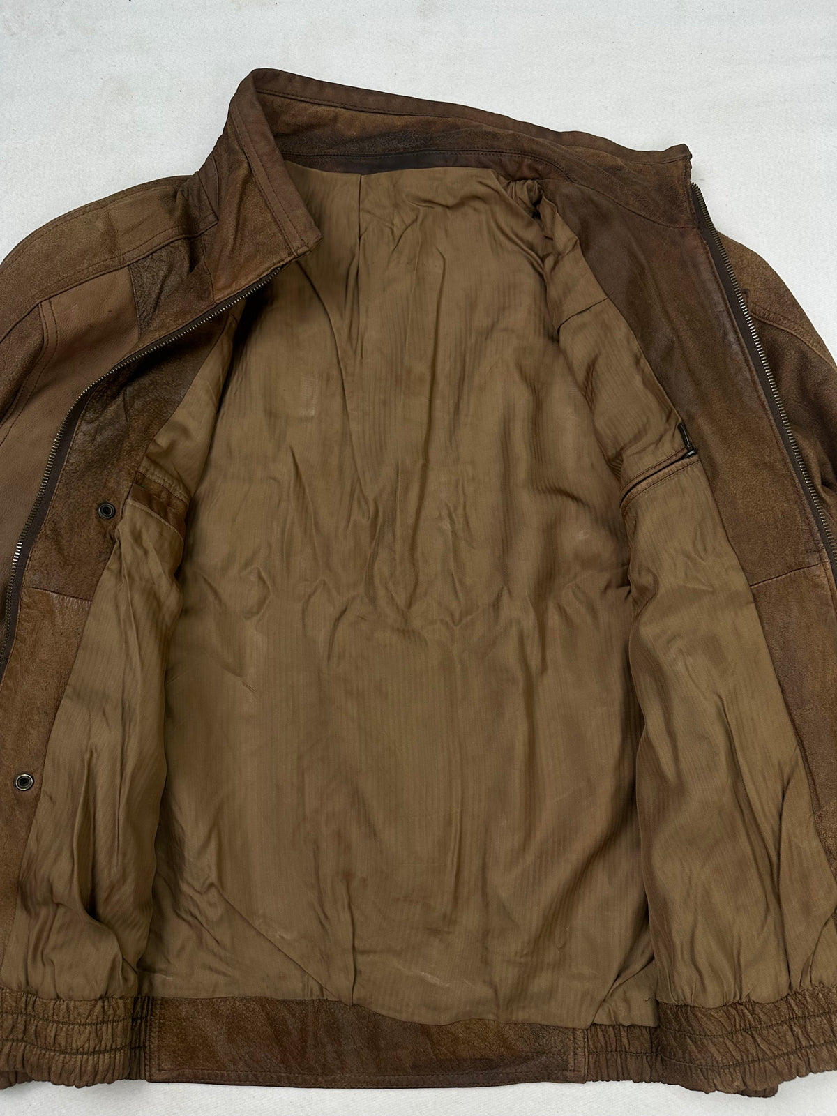 The size XL brown leather flight jacket opened to show the lining