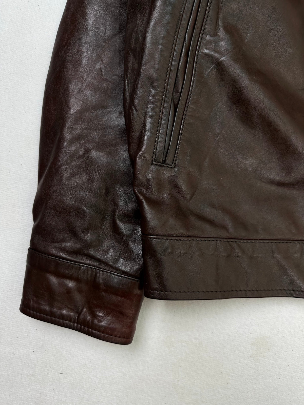 Close detail of the pockets and cuff on the size S burgundy leather vintage jacket