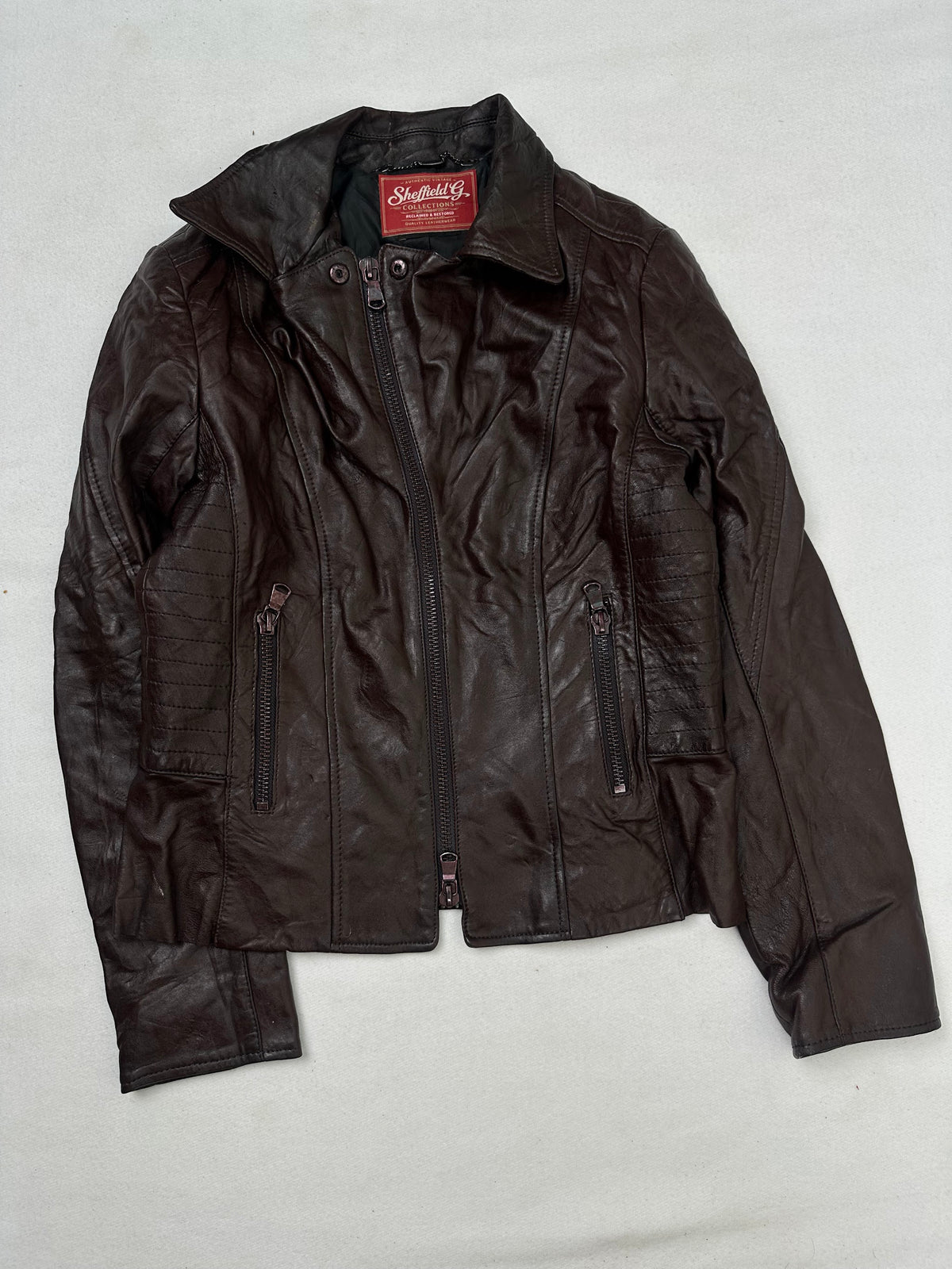 Front of the size XS burgundy leather biker jacket, laid flat and unedited