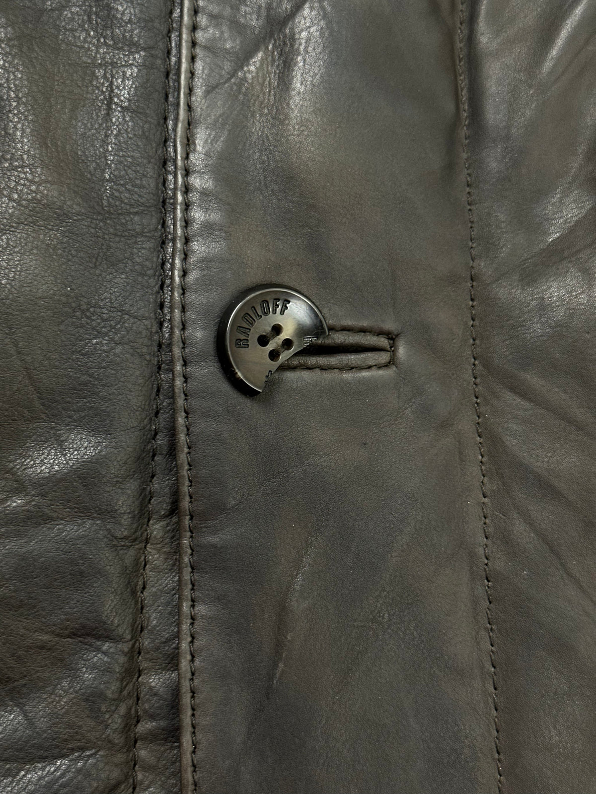 Side pocket and hem of the size XL brown leather field jacket, up close