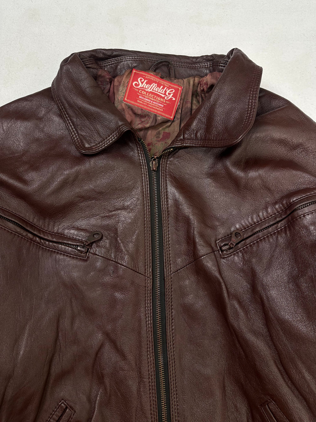 Collar and zip of the size L burgundy leather harrington jacket, up close