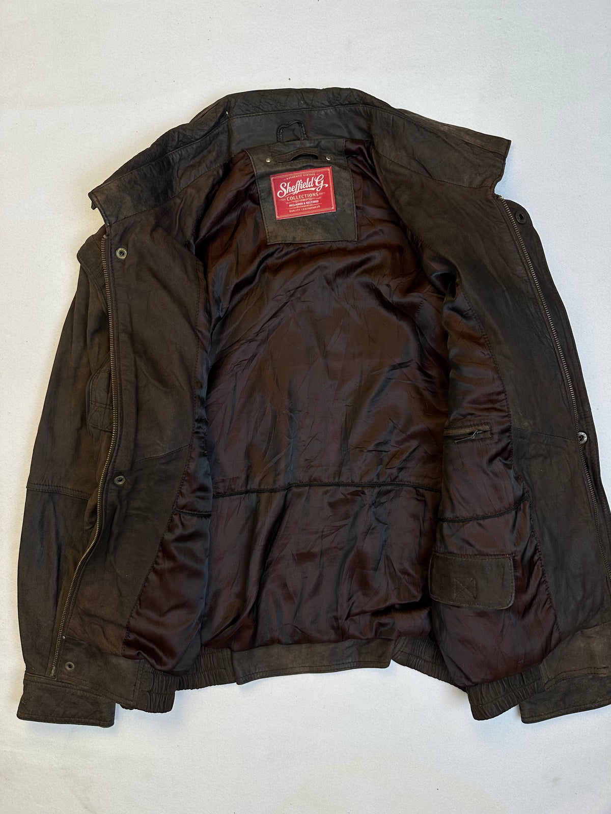 The size L brown leather flight jacket opened to show the lining