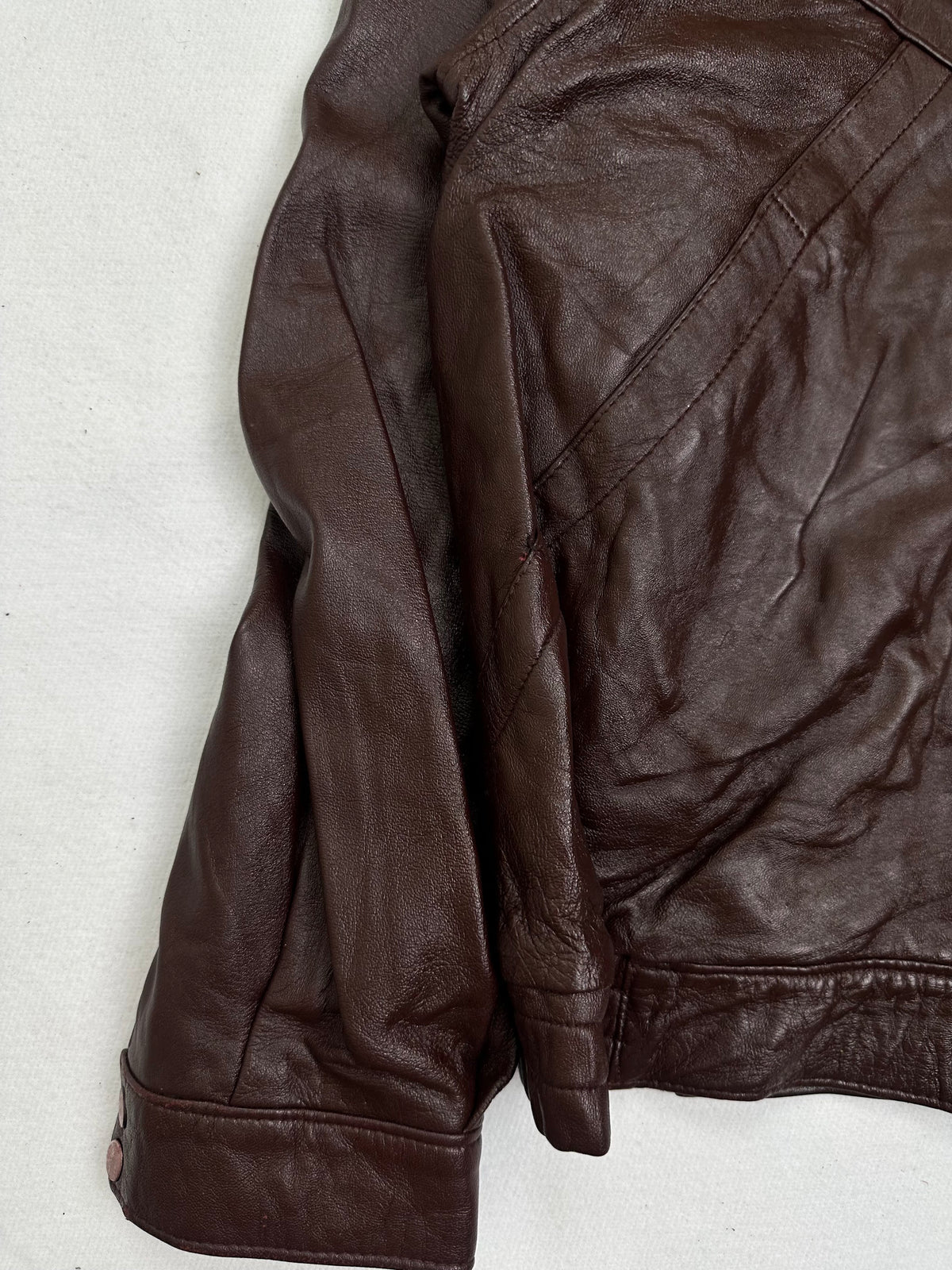 Close detail of the pockets and cuff on the size L burgundy leather vintage jacket